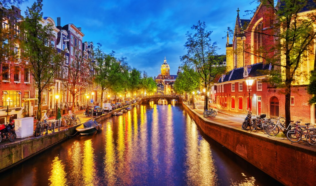 Un canale illuminato e la Westerkerk sullo sfondo. Credits V_E / Shutterstock